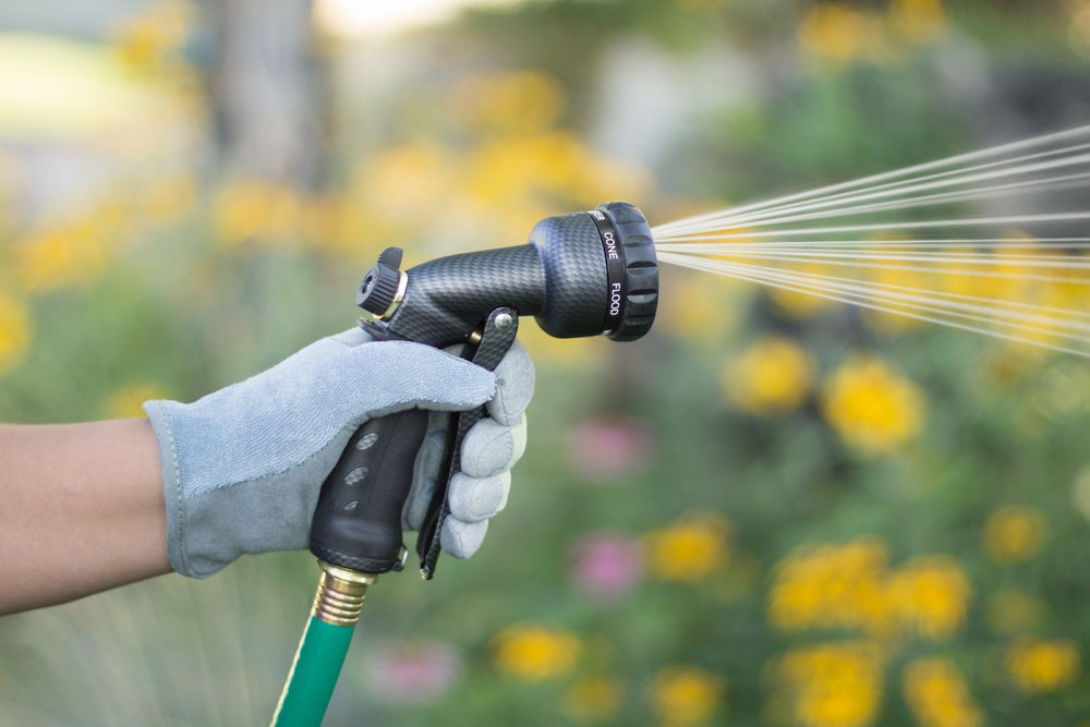 Graphite colored seven pattern zinc front trigger nozzle emitting a cone spray pattern of water. 